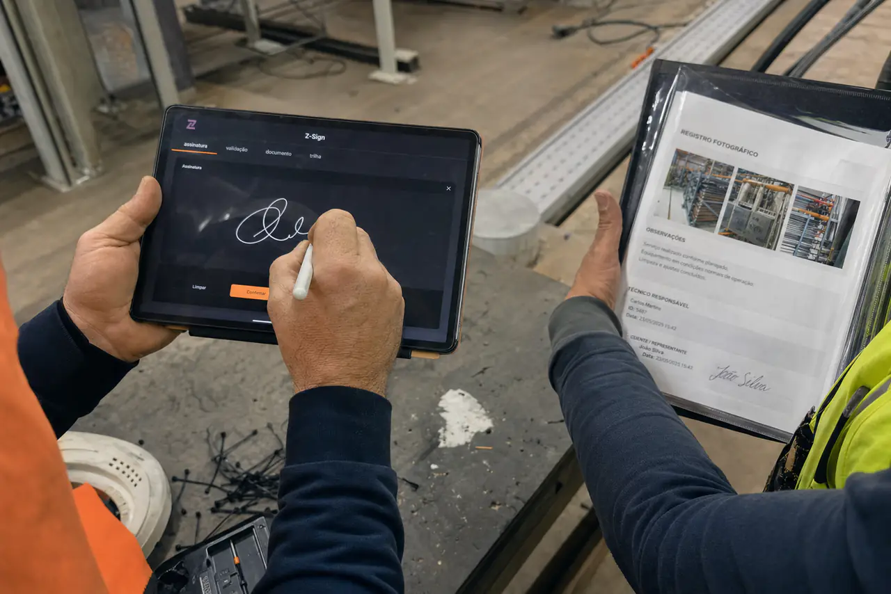 Mãos assinando um encerramento de serviço na tela de um tablet, com a prancheta ao lado